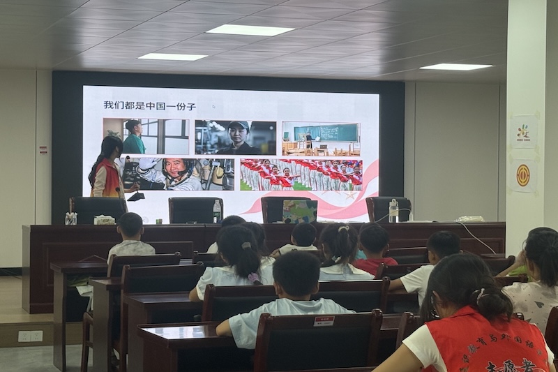 图：宣讲队员面向小学生开展爱国主题双语课堂授课互动.jpg