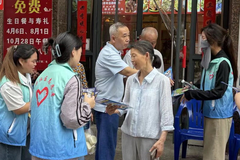图为志愿者发放反诈宣传单并讲解.JPG